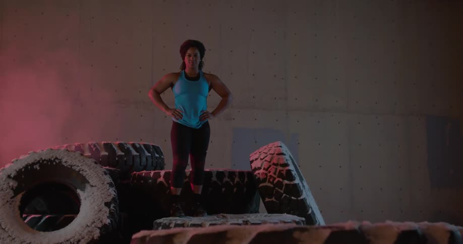 A woman is posing on some large tires