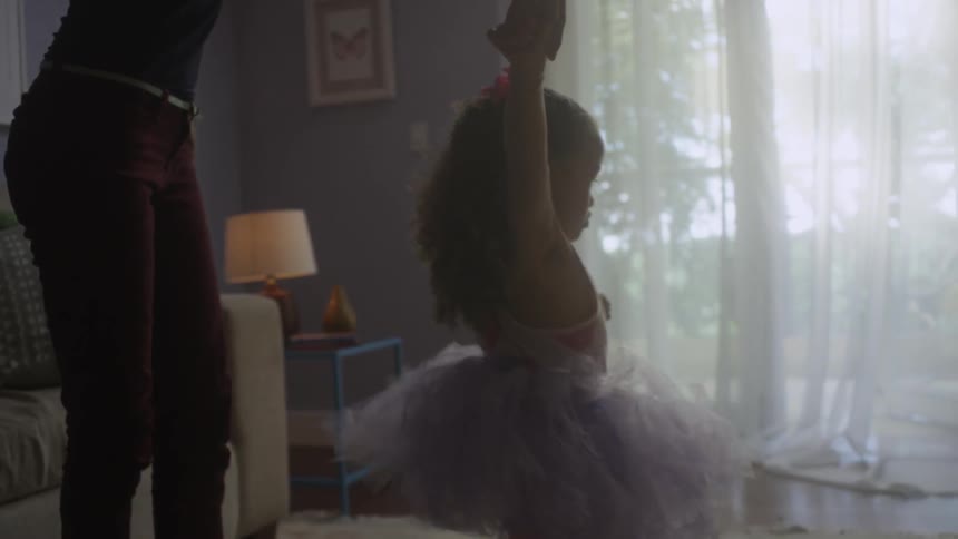 A woman and helps her toddler child dance