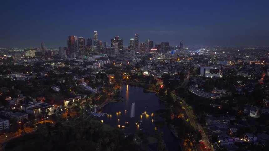 A beautiful aerial view of the Downtown Los Angeles skyline at dusk with the illuminated lotus flower lanterns on Echo Park Lake in the foreground