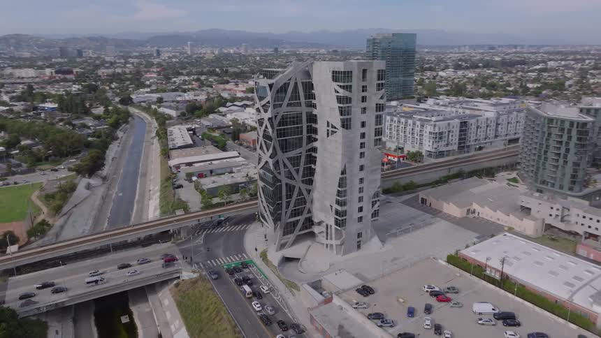 An aerial view slowly pushes in and orbits the unique, abstract architecture of the (W)rapper Tower in Los Angeles