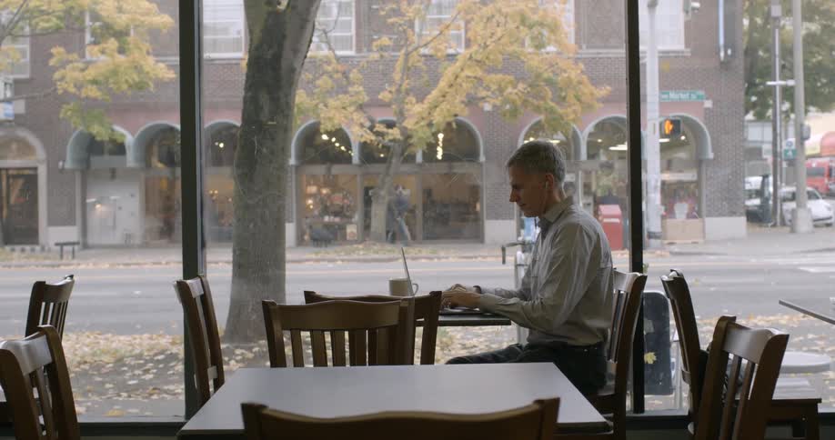A man works on a laptop in a coffeeshop