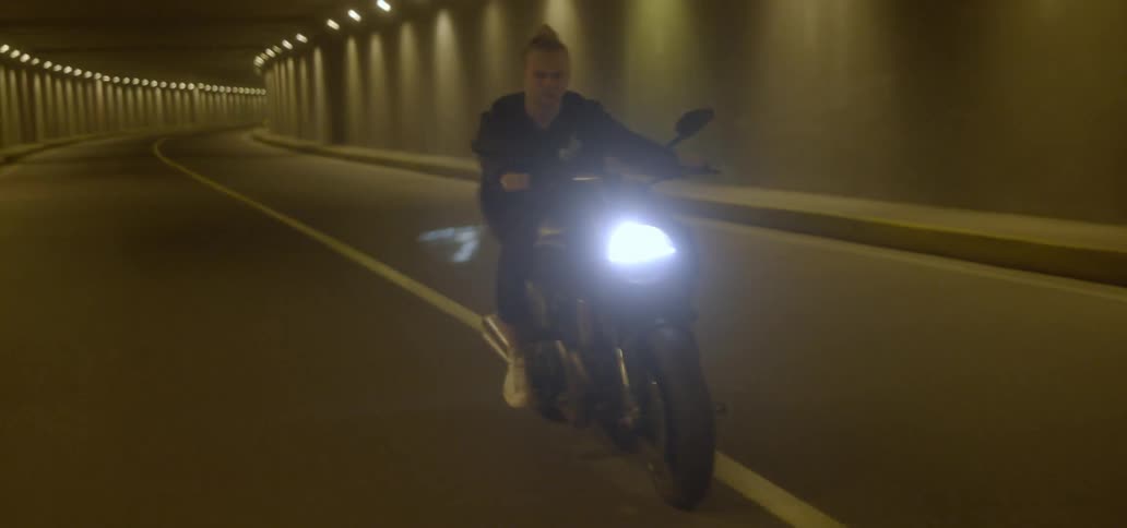 A man rides his motorcycle in a tunnel