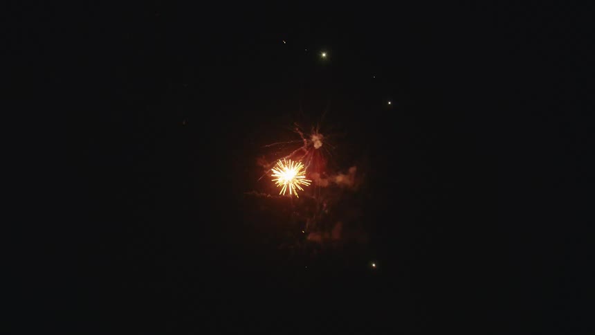 A seamless loop of colorful fireworks bursting and sparkling in the dark night sky