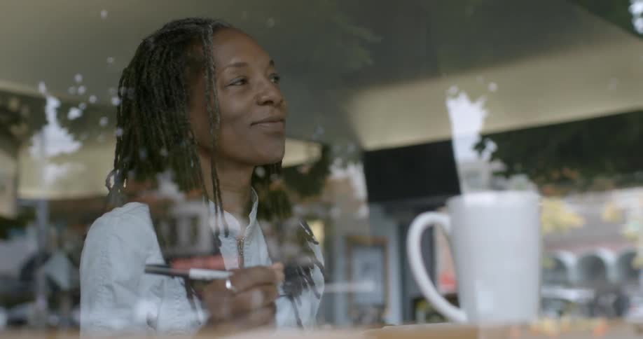 A woman smiles as she uses a marker inside