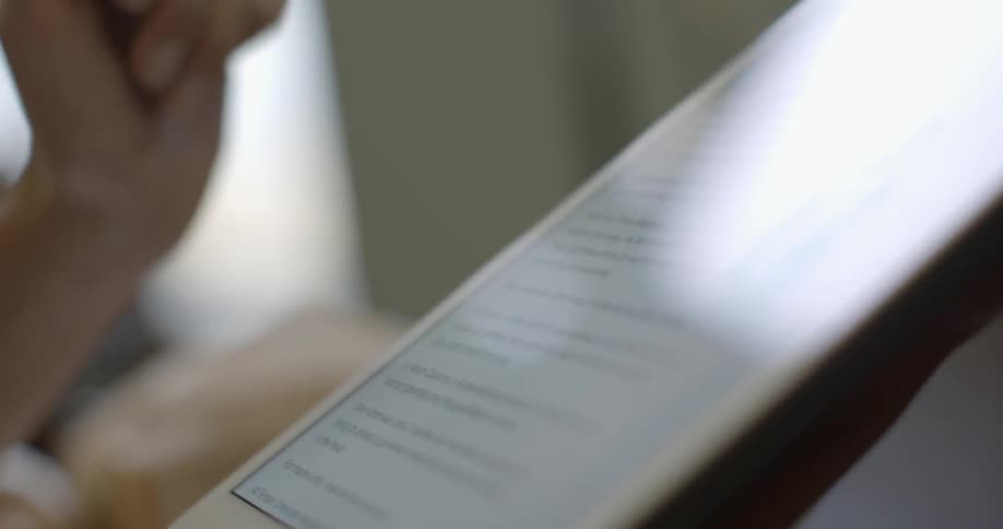 A woman scrolls on a tablet