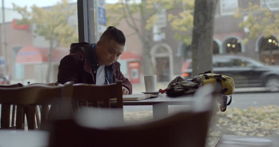 A man is sitting at a table writing