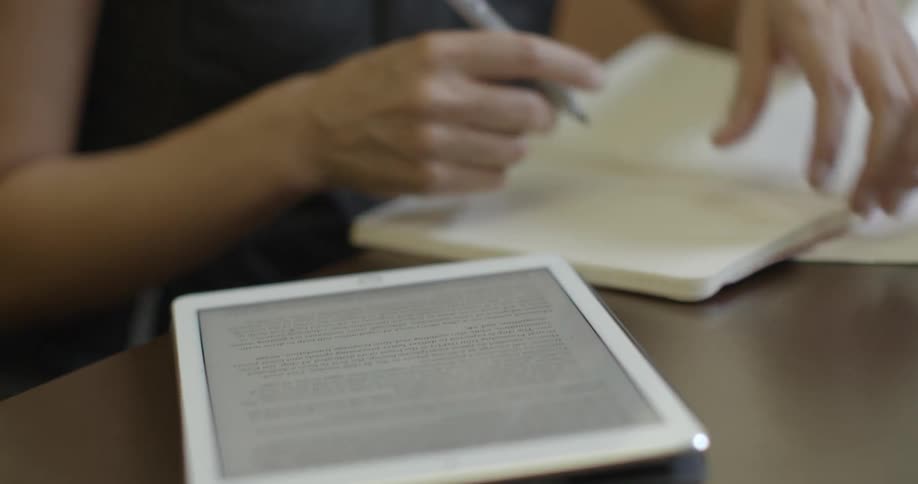 Person sits at a desk writing in a notebook