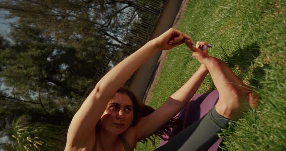 A woman performs various yoga poses, including an advanced leg stretch, on a purple mat in a sunny garden