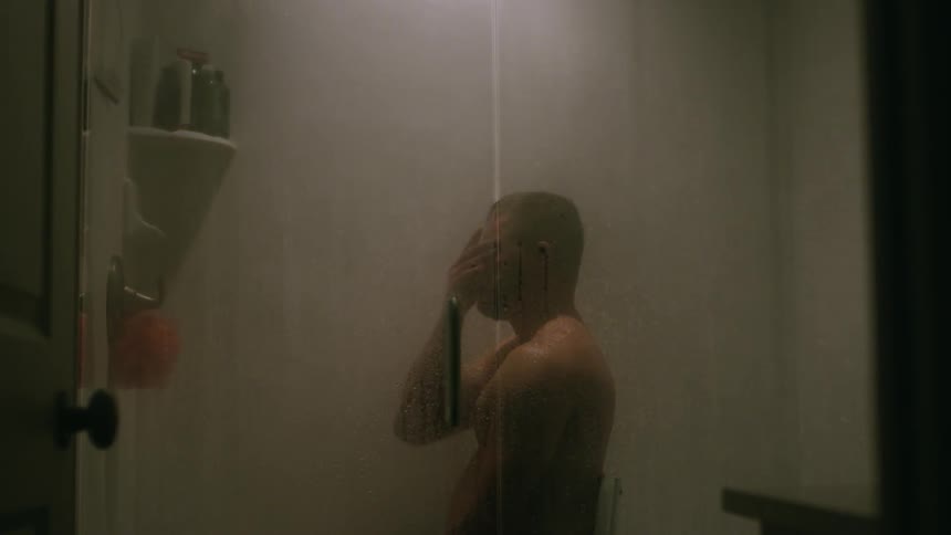 A man is sitting on a chair as he takes a shower