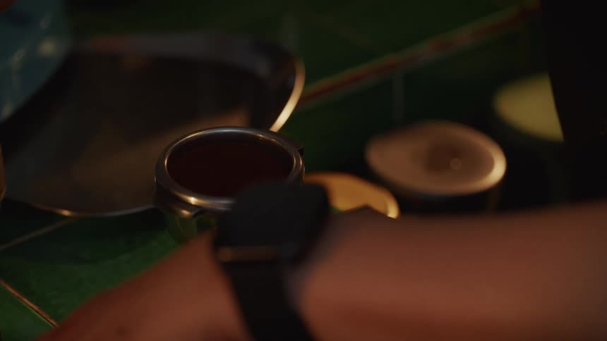 A close-up of a barista tamping coffee grounds into a portafilter to prepare an espresso