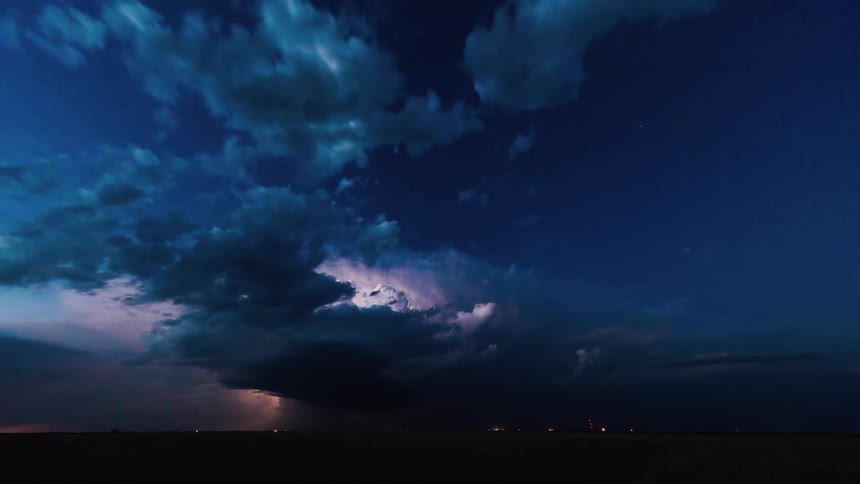 Storm clouds and lightning move over a field