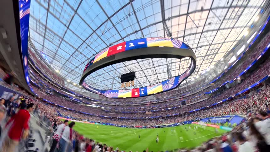 A surreal, wide-angle hyperlapse pans through the energetic crowd of a massive, modern soccer stadium during a live match