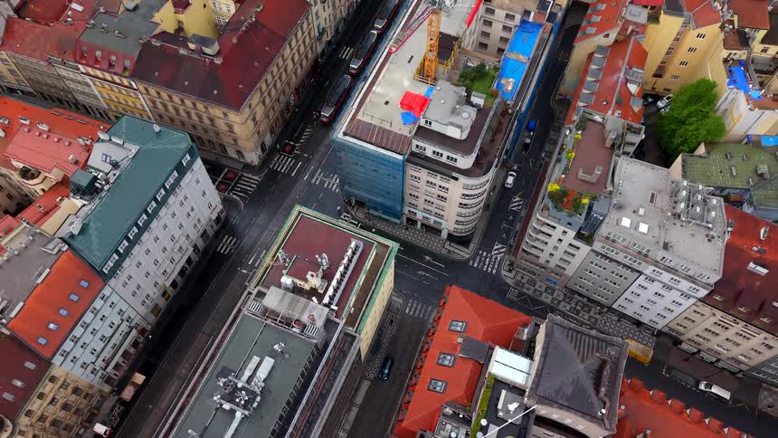 Aerial birds-eye view of a city intersection revealing the urban landscape and traffic with the camera slowly rising