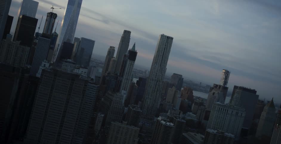 A view of a city skyline and body of water on a cloudy evening