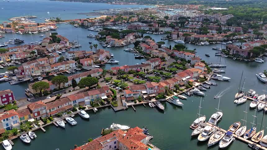 A stunning aerial view reveals the intricate canals and colorful waterfront homes of Port Grimaud, a luxurious marina town on the French Riviera