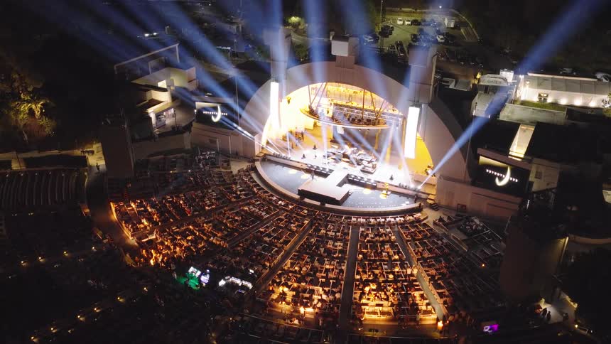 Spectacular aerial footage shows the iconic Hollywood Bowl amphitheater illuminated by stunning spotlights during a live nighttime concert