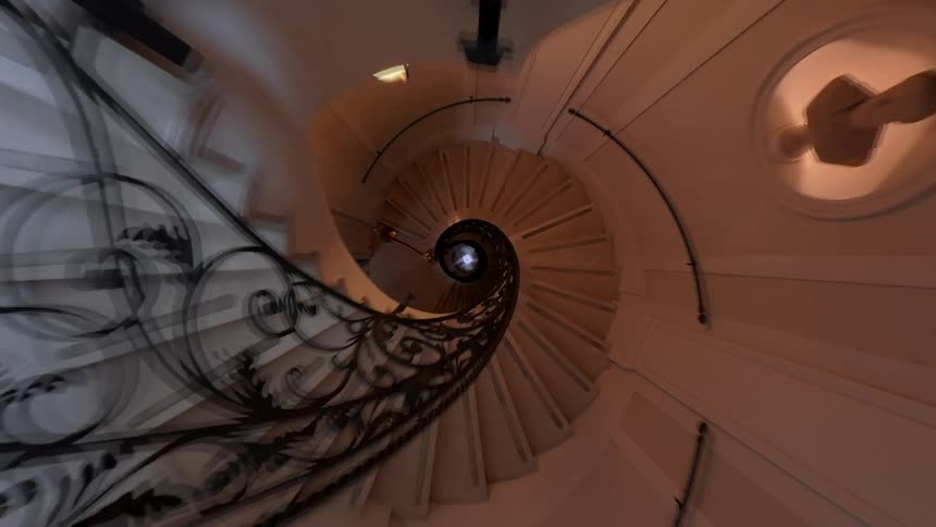 A mesmerizing top-down hyper-lapse journey down an elegant spiral staircase with ornate iron railings