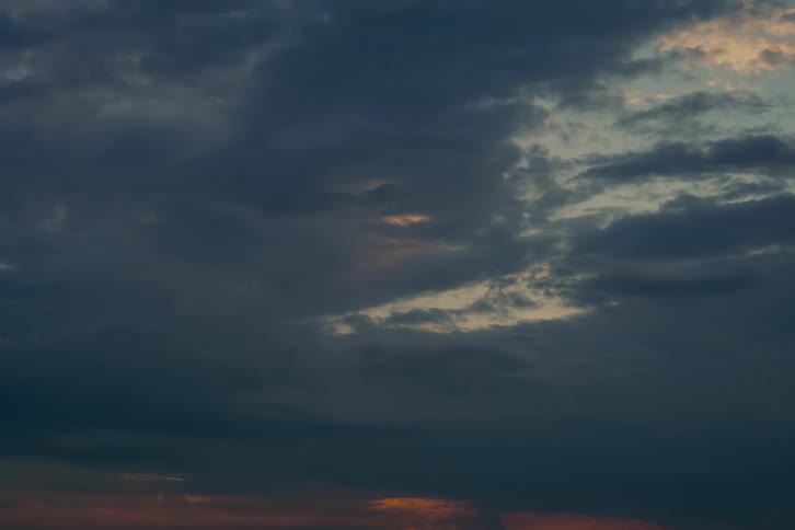 A still shot of a dark, moody sky with heavy clouds during twilight