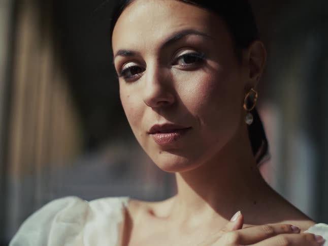 A close-up portrait of a beautiful bride with dark hair looking gently into the camera