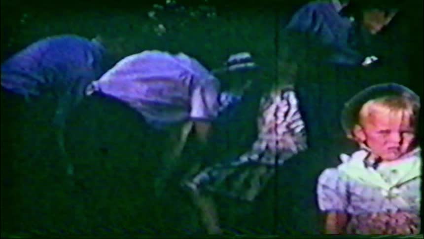 Vintage 1950s home movie captures a young girl and boy dressed in charming traditional folk costumes