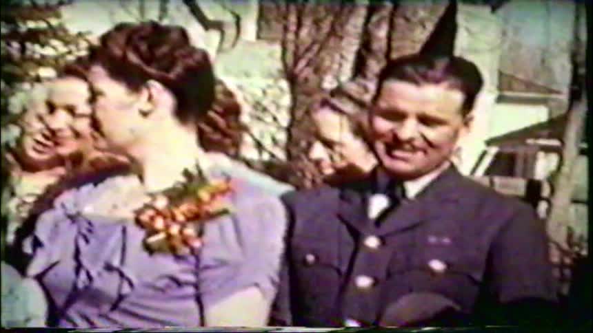 A vintage home movie captures a family gathering in the 1940s, featuring a soldier, a young girl, and several women posing together