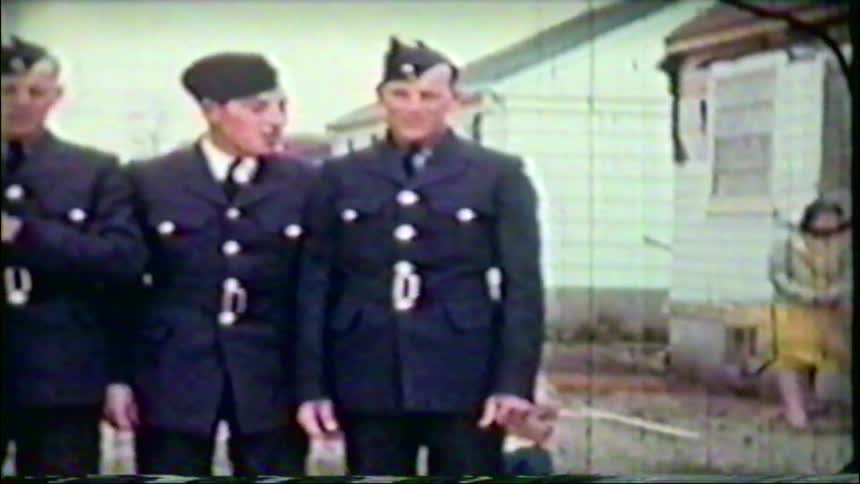 Vintage home movie footage captures three friendly airmen in uniform joking around with each other outdoors