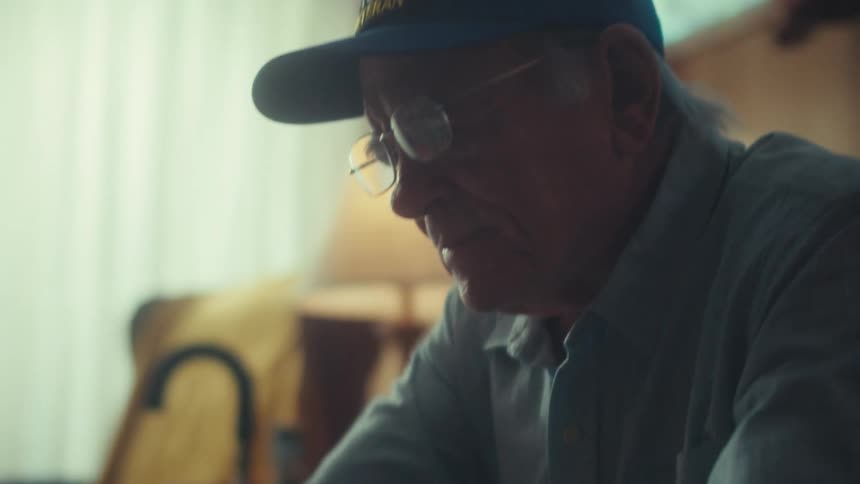 A pensive elderly Air Force veteran meticulously sorts through a pile of receipts while managing his finances at a desk