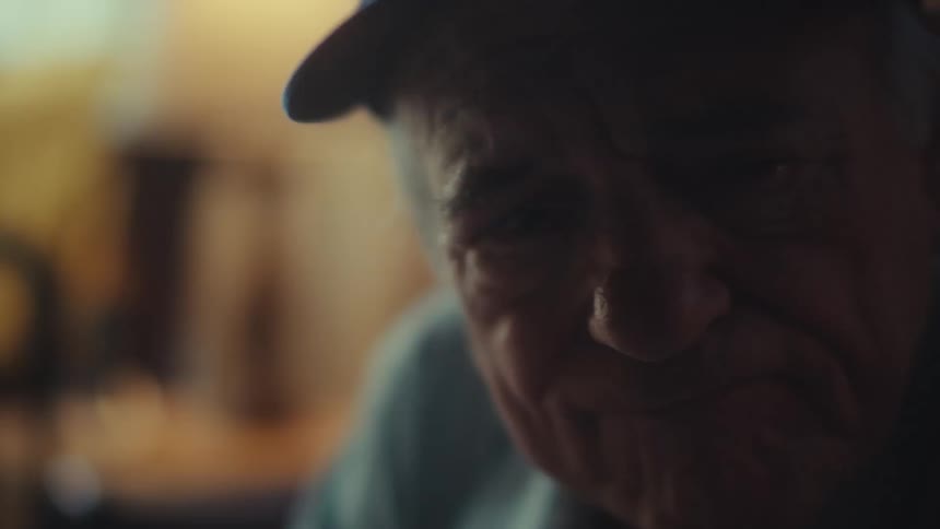 A slow push-in shot reveals the somber and thoughtful face of an elderly Air Force veteran sitting alone