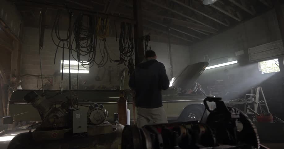 A person works on a car in a garage