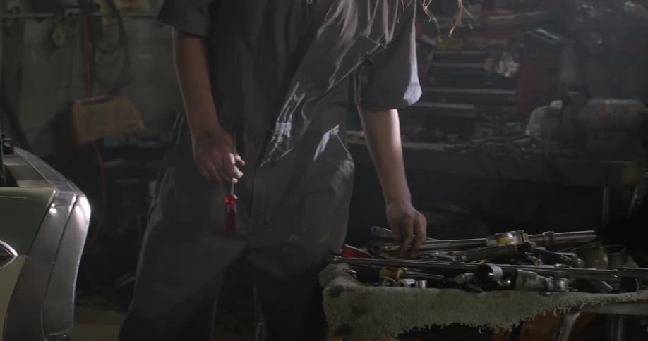 A woman is working on a car