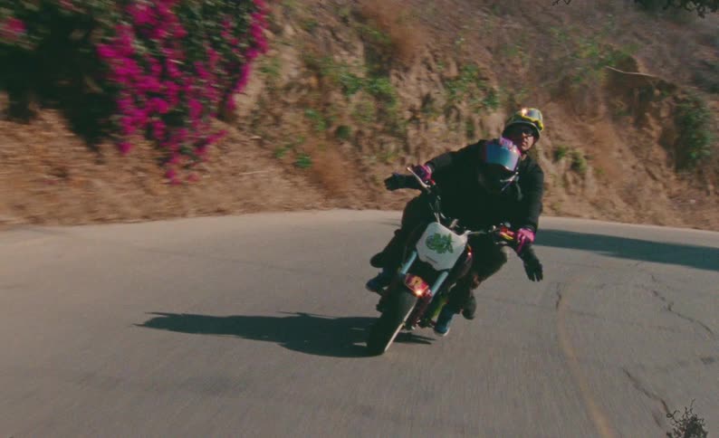 Slow motion front view of two bikers in helmets enjoying a ride on a curvy road in the hills