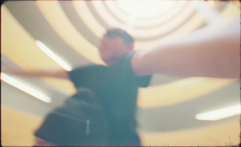Low angle vintage-style shot of a cheerful father carrying his son on his shoulders inside a circular parking garage