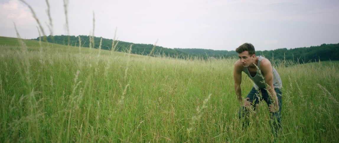 A man takes a breather in a field of tall grass