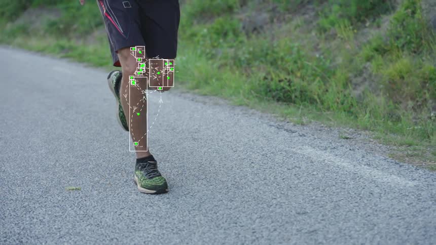A slow-motion shot of a runner's legs with biomechanical motion tracking graphics analyzing his form