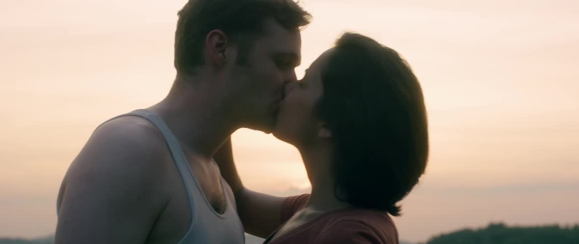 Couple kissing outdoors at sunset
