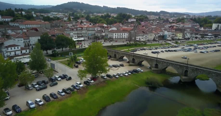 Cars are parked in a lot before a canal