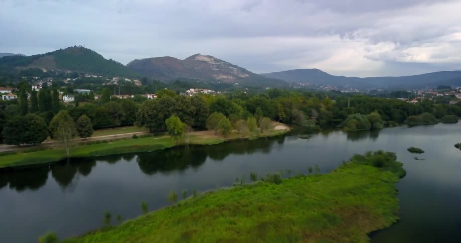 A river flows through an area with mountains and neighborhoods