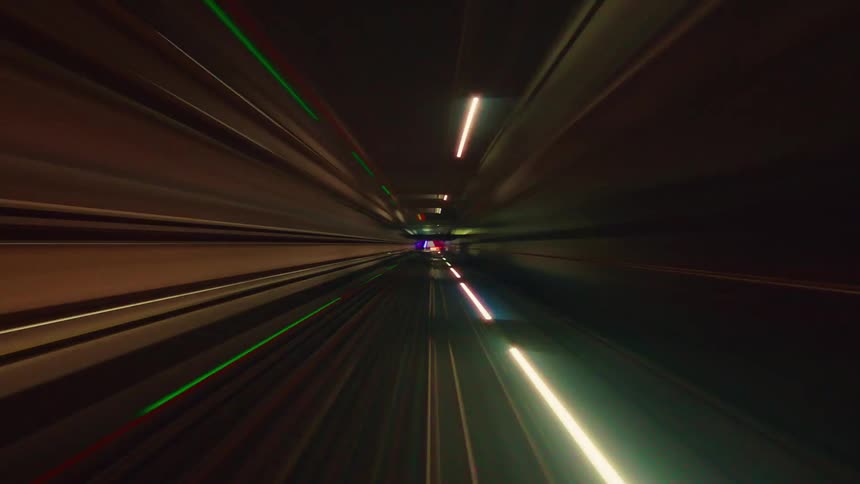 Psychedelic and abstract light trails from a fast-moving train in a futuristic tunnel