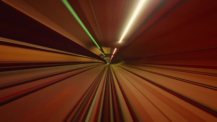 Abstract first-person view timelapse of a high-speed train ride through a colorful, futuristic subway tunnel