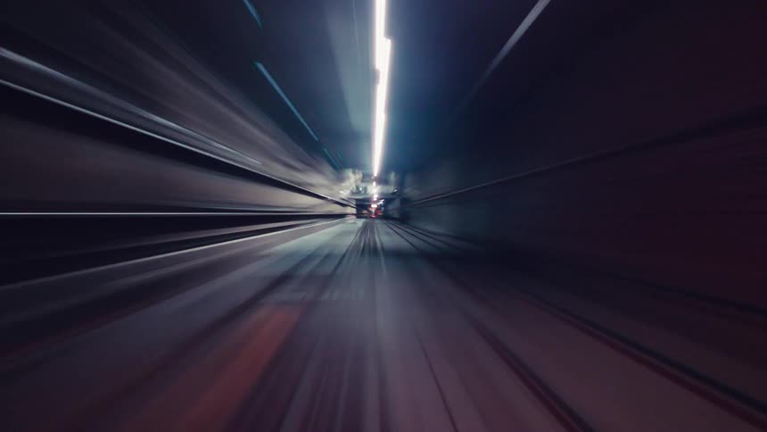 A futuristic point-of-view journey speeds through a subway tunnel creating abstract, colorful light trails
