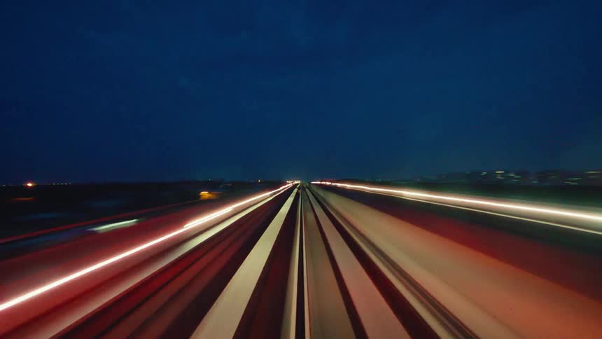 Experience a futuristic ride on a high-speed train at night through a dazzling city skyline in this stunning timelapse