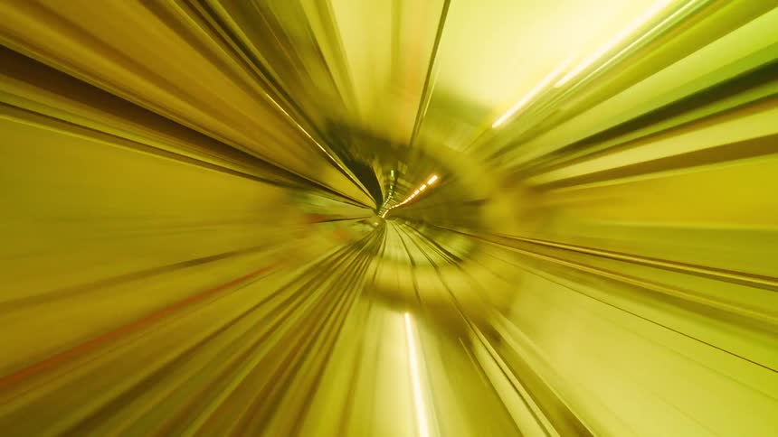Futuristic, abstract POV time-lapse of a high-speed journey through a brightly lit, colorful subway tunnel