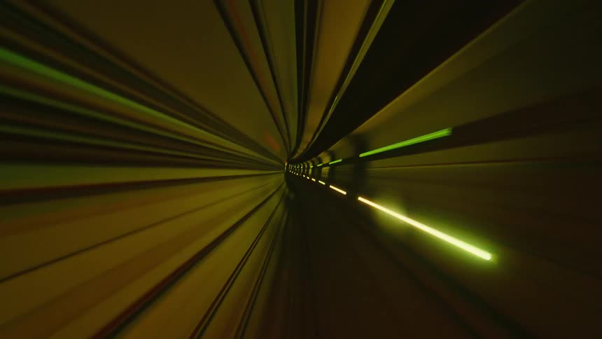 Futuristic, abstract POV time-lapse of a high-speed journey through a brightly lit, colorful subway tunnel
