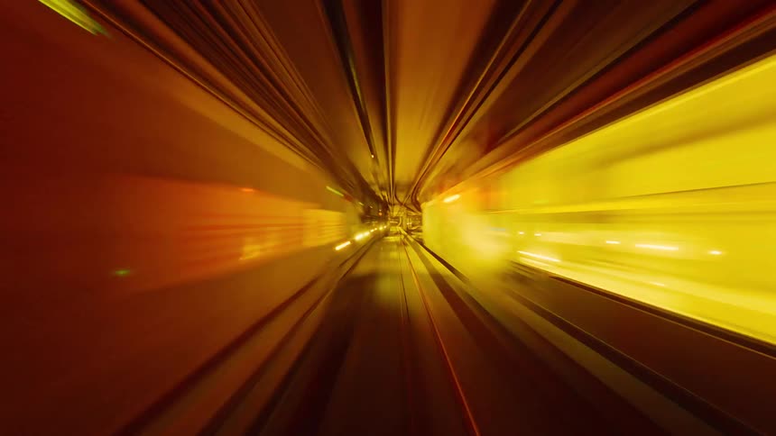 A futuristic point-of-view time-lapse of a high-speed journey through a subway tunnel with streaking, colorful lights