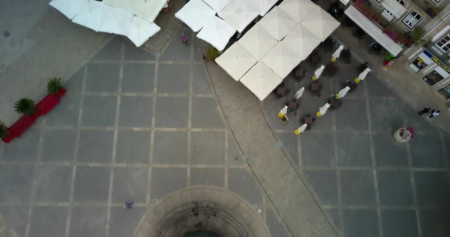 People walk along the square outside a building