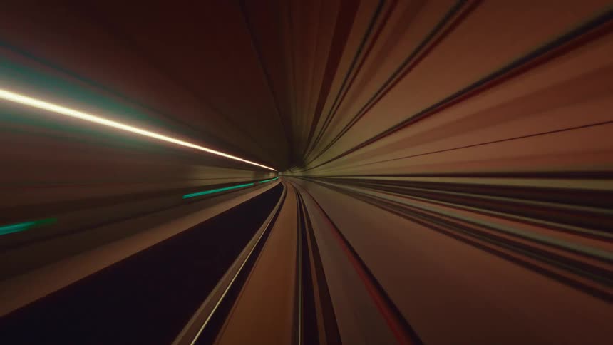 A trippy and futuristic point-of-view time-lapse of a train speeding through an underground tunnel, creating vibrant streaks of colorful light