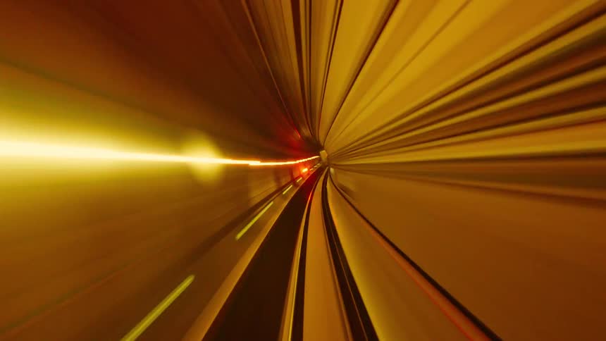 Futuristic hyper-lapse from the front of a subway train as it speeds through a tunnel, creating vibrant, abstract light streaks