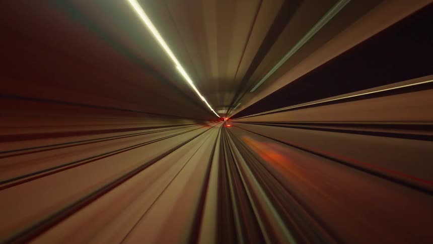 A mesmerizing abstract time-lapse from the front of a subway train speeding through a tunnel of vibrant, colorful light streaks