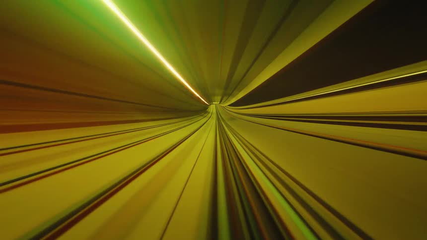 A surreal point-of-view time-lapse of a train speeding through a tunnel, with colorful light trails creating a psychedelic effect