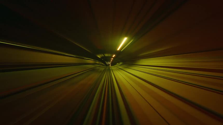 An abstract and surreal POV timelapse of a train speeding through a neon-lit tunnel, creating vibrant light streaks